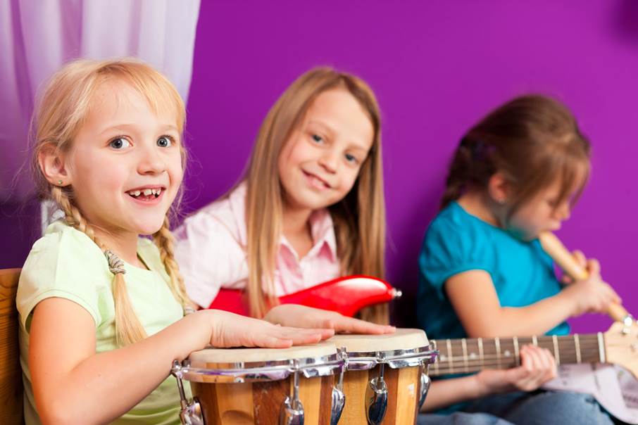 Tre unga tjejer spelar instrument.