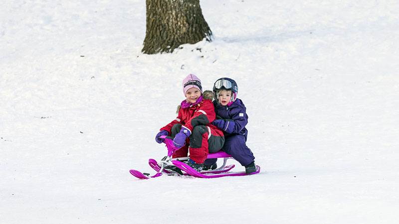 Två tjejer åker snowracer.